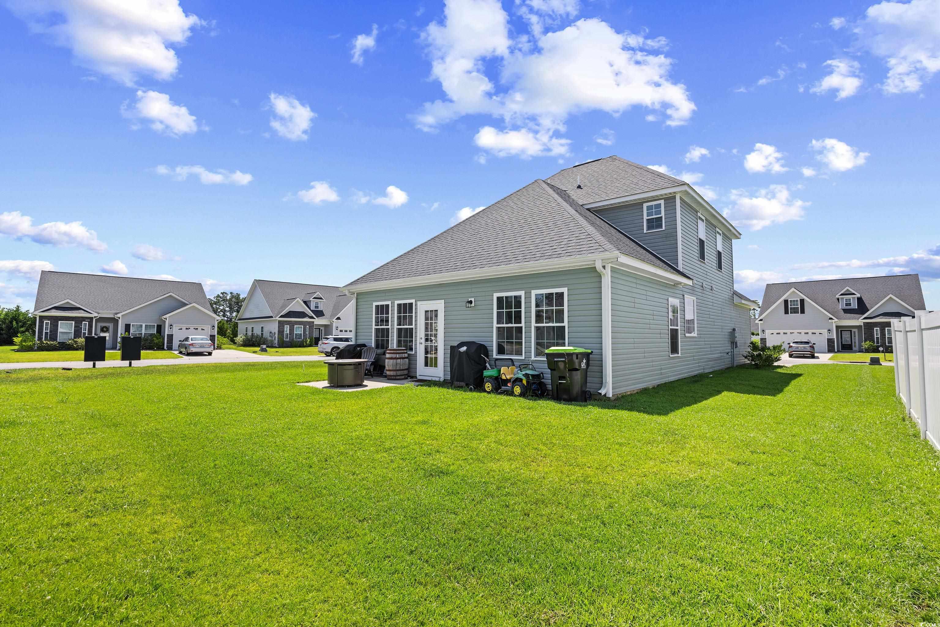 704 Hobonny Loop Longs, SC 29568 - Photo 34 of 36 Back of house featuring a yard and a shingled roof