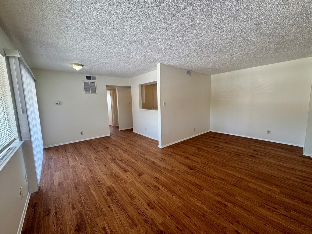 8905 Parkfield Drive, Unit 201 Austin, TX 78758 - Photo 3 of 13 an empty room with wooden floor and windows