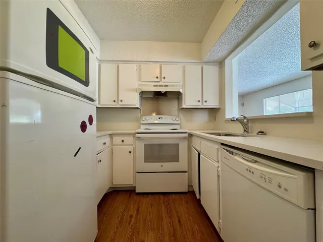 a kitchen with white cabinets and white appliances