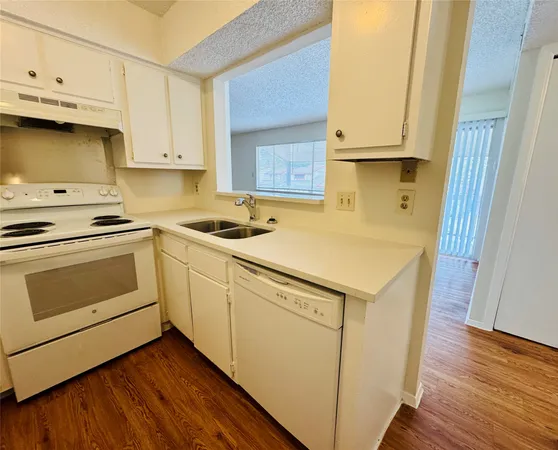 a kitchen with white cabinets and white appliances