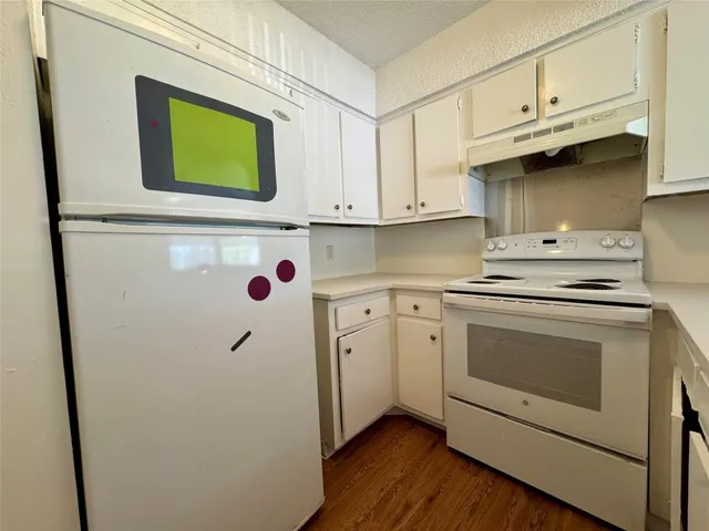 a kitchen with stainless steel appliances white cabinets and a refrigerator