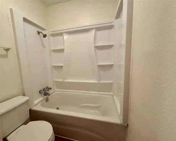 a bathroom with a toilet and a bathtub
