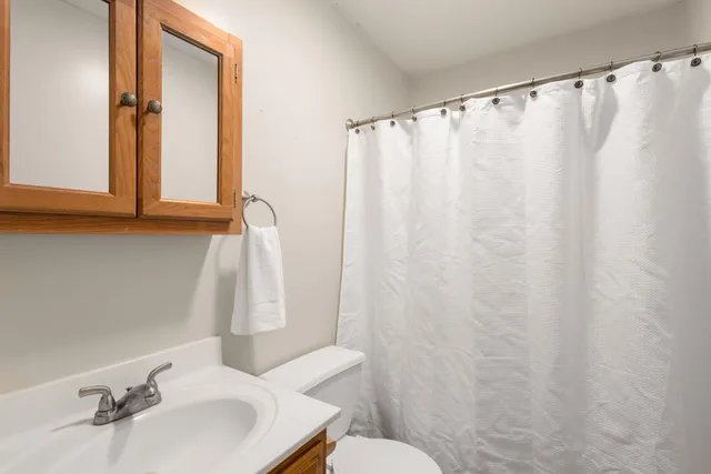 a bathroom with a sink a toilet and a mirror