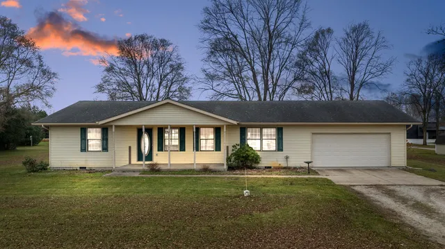 a front view of a house with a garden and yard