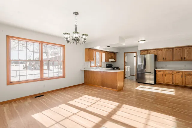 a view of a kitchen with kitchen island granite countertop a stove top oven a sink a counter space and cabinets