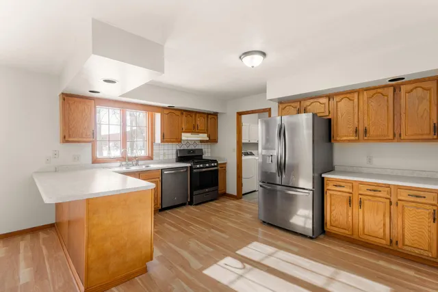 a kitchen with granite countertop a refrigerator stove top oven and sink