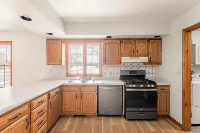 a kitchen with a stove sink and cabinets