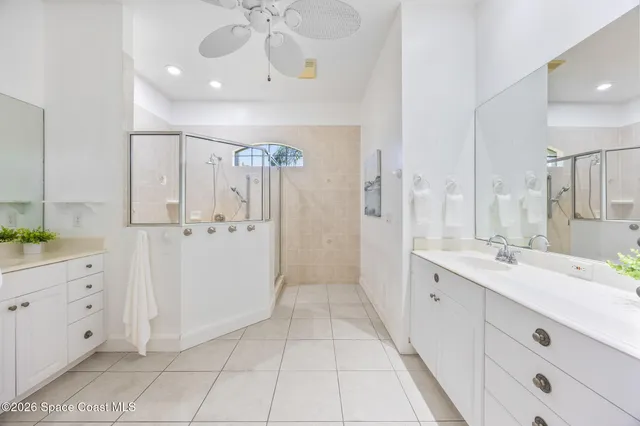 a bedroom with a bed and a chandelier fan