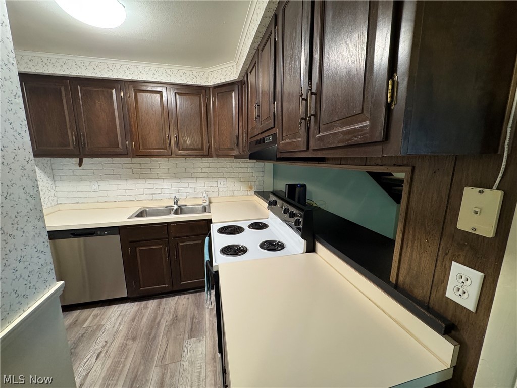 7294 Fox Mill Road, Unit 19D Mentor, OH 44060 - Photo 16 of 27 Kitchen featuring wood-finish cabinetry, white brick-pattern backsplash, a dual basin stainless steel sink, and light-toned countertops
