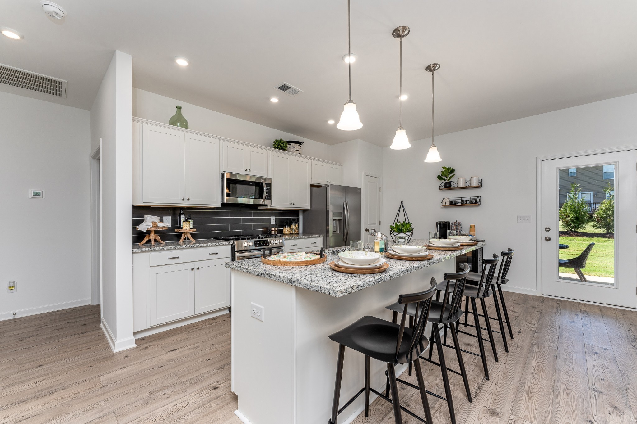 1116 Southerlynn Drive White House, TN 37188 - Photo 7 of 18 a kitchen with a dining table chairs stainless steel appliances and wooden floor