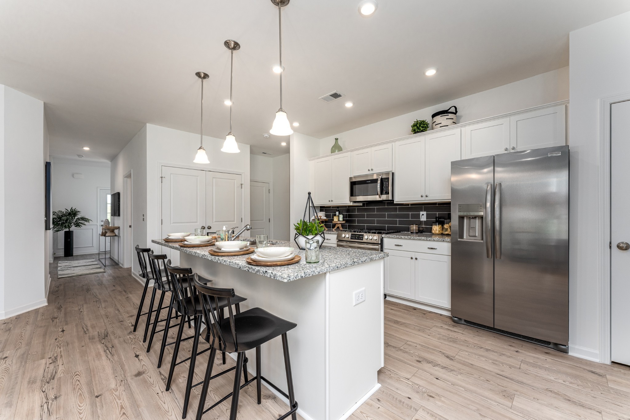 1116 Southerlynn Drive White House, TN 37188 - Photo 8 of 18 a kitchen with stainless steel appliances kitchen island granite countertop a refrigerator a stove a sink a dining table and chairs with wooden floor