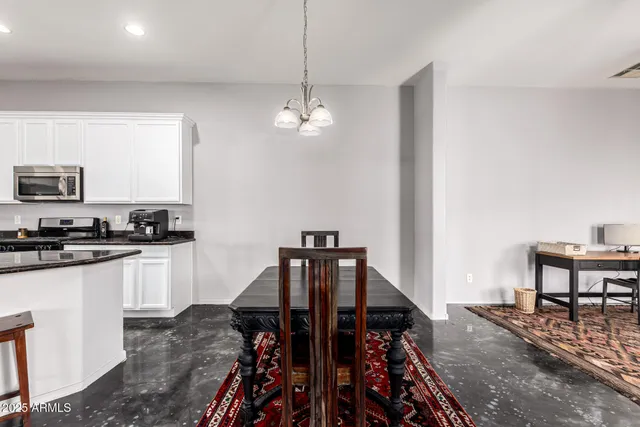 a view of a kitchen with kitchen island a dining table chairs and a wooden floor