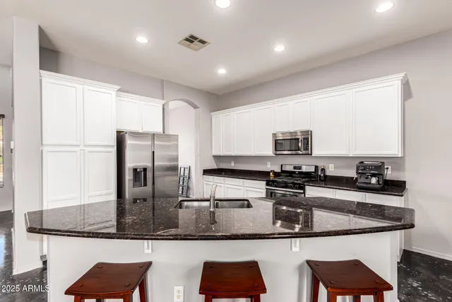 a kitchen with stainless steel appliances granite countertop a sink refrigerator and microwave