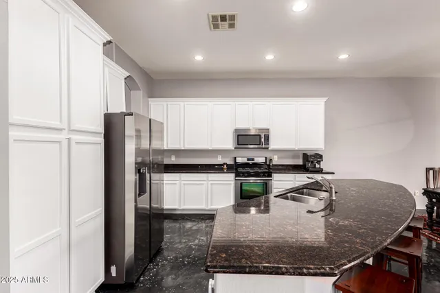 a kitchen with a refrigerator a stove a sink a counter top space and cabinets