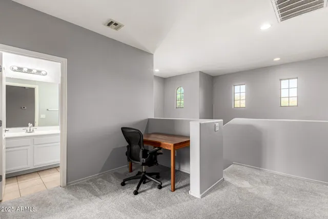 a view of a workspace with furniture and a window