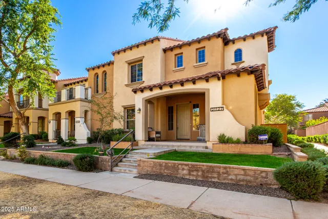 a front view of a house with a yard and potted plants
