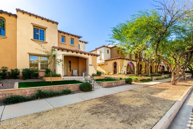 a view of a white house with a yard and large tree
