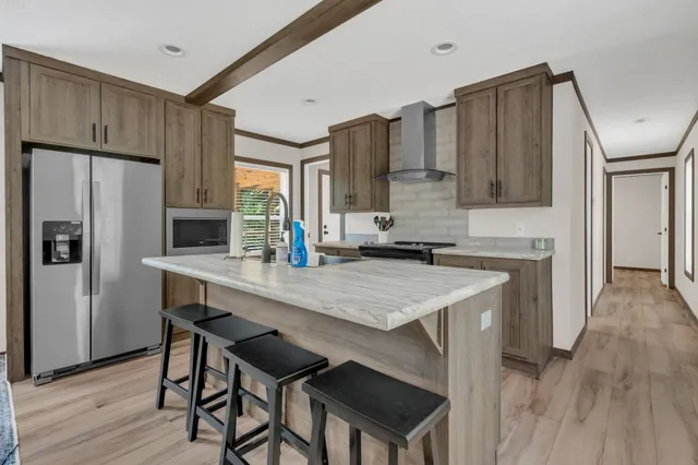 a kitchen with stainless steel appliances a table chairs refrigerator and sink