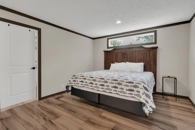 a bedroom with a bed and wooden floor