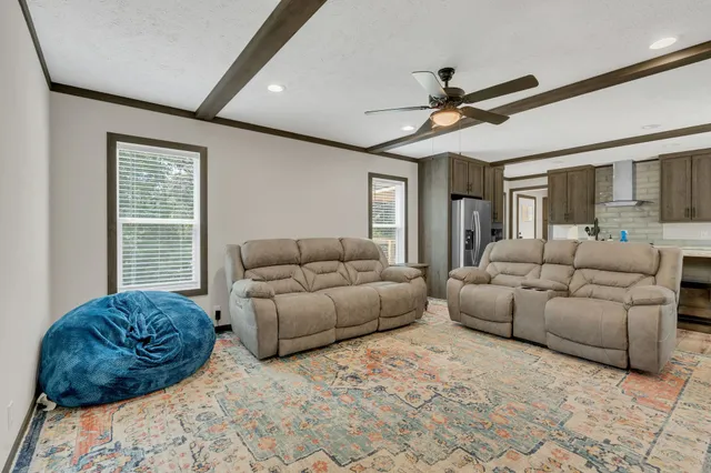 a living room with furniture ceiling fan and a window
