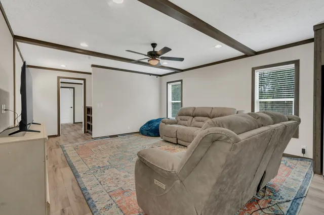 a living room with furniture a ceiling fan and a rug