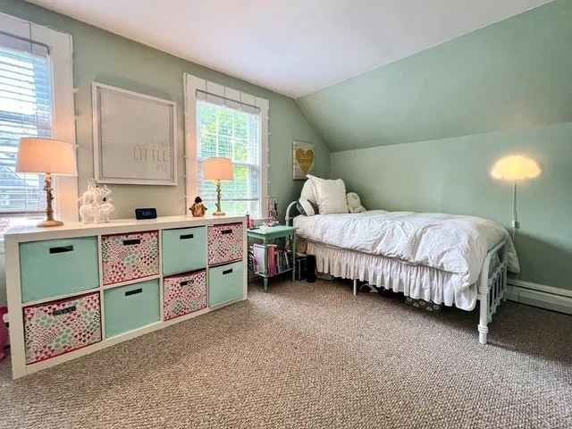 a bedroom with a bed dresser and a window