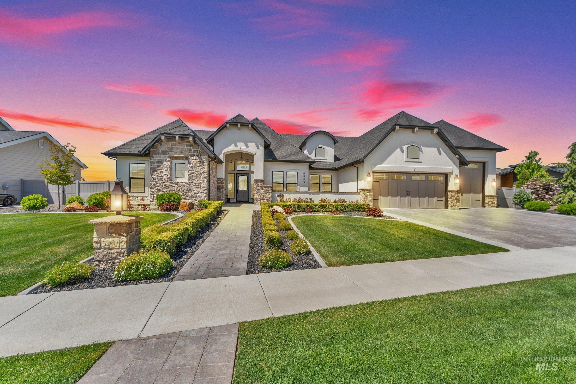 6585 South Pemberley Way Meridian, ID 83642 - Photo 3 of 43 Stucco and stone facade with dark gabled rooflines, a paved walkway, and a concrete driveway