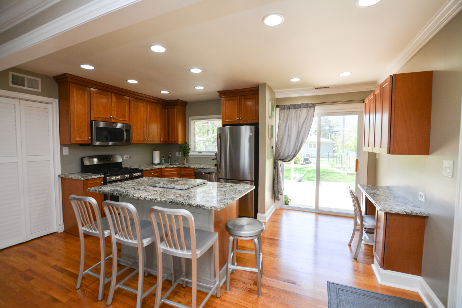 36 Johnathan Road Lake Zurich, IL 60047 - Photo 15 of 25 a kitchen with stainless steel appliances granite countertop wooden floor a refrigerator a stove top oven and a dining table with wooden floor