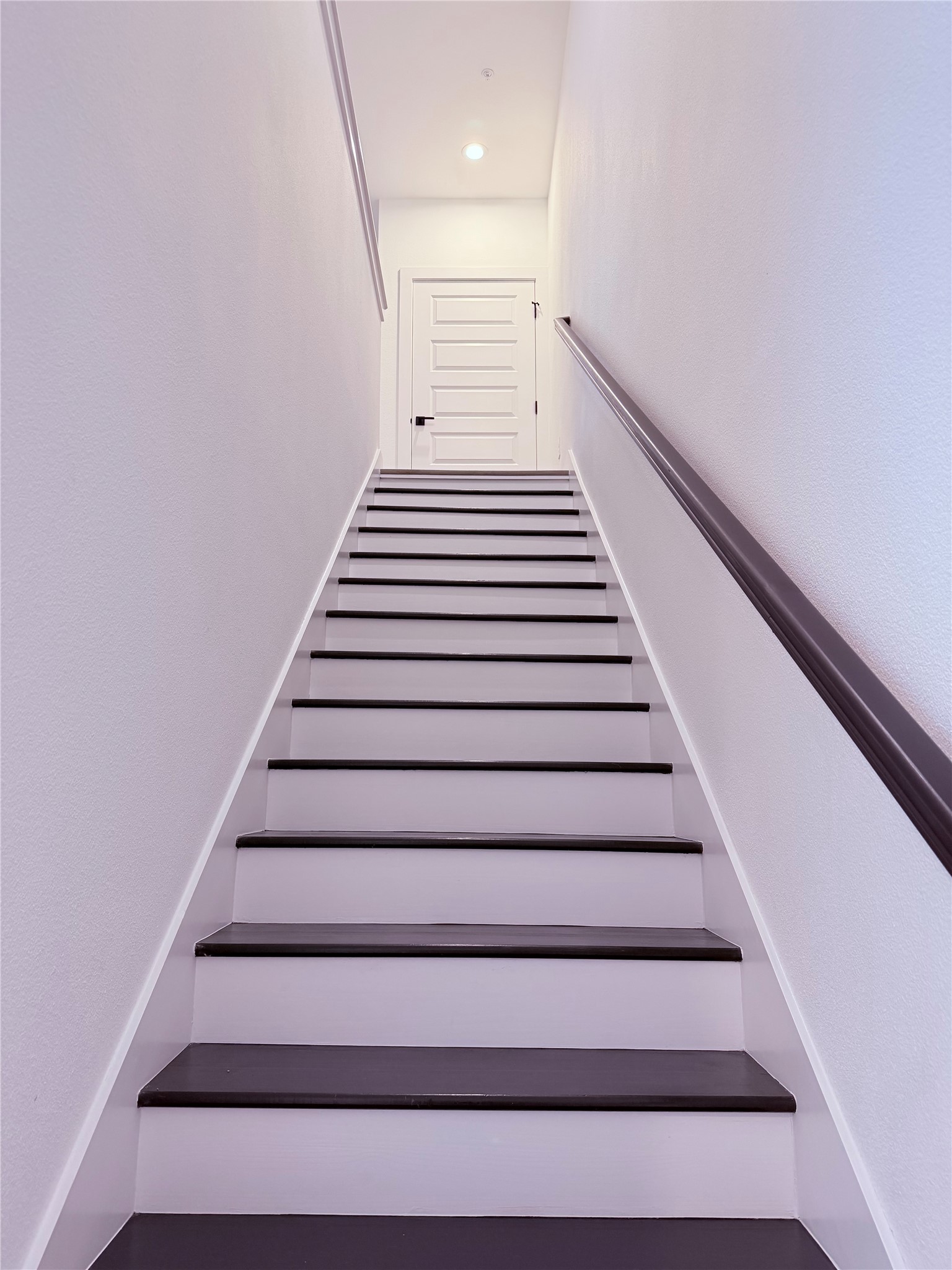 1417 Kramer Lane, Unit 7 Austin, TX 78758 - Photo 13 of 24 Ascend to privacy on these dark-stained wood stairs with a sleek banister leading to a paneled door.