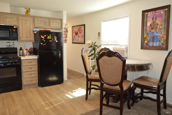 a kitchen with a table chairs refrigerator and microwave