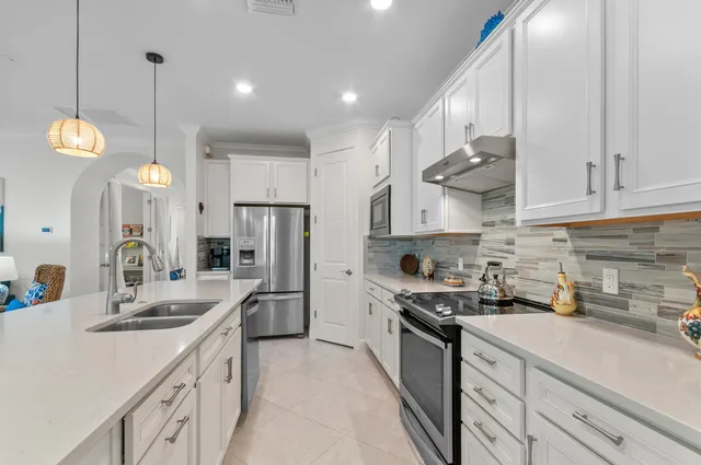 a kitchen with stainless steel appliances granite countertop a sink a stove and a refrigerator