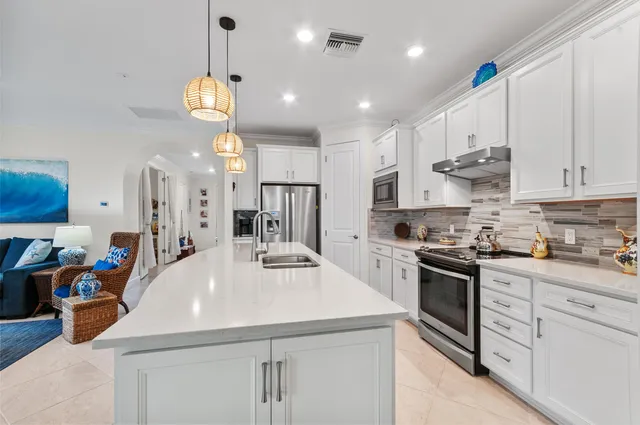 a kitchen with stainless steel appliances kitchen island granite countertop a sink a stove and cabinets