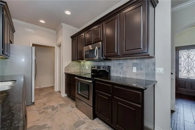 a kitchen with stainless steel appliances granite countertop a stove and a refrigerator
