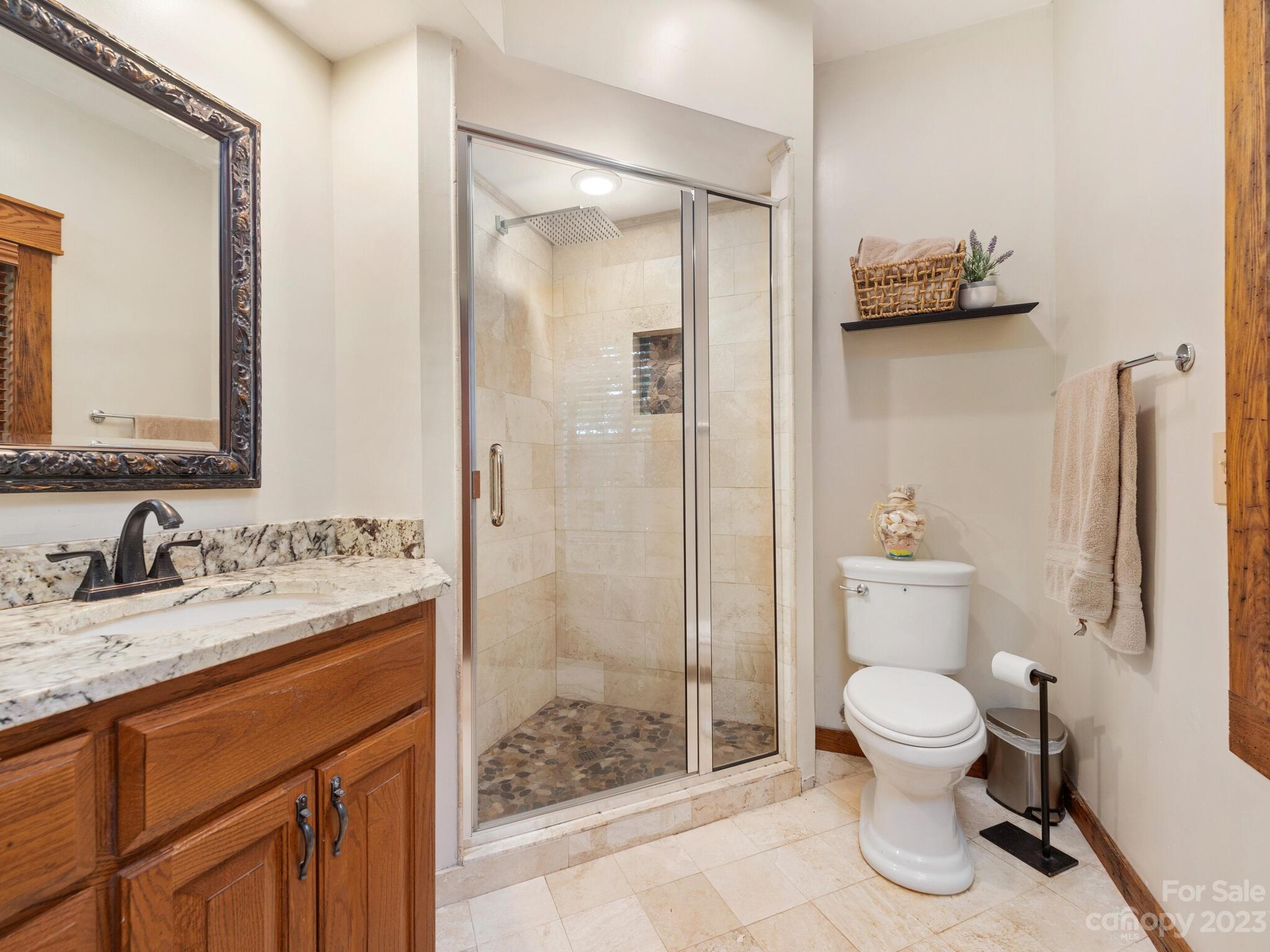 574 Golden Road Columbus, NC 28722 - Photo 36 of 48 a bathroom with a granite countertop sink toilet and shower