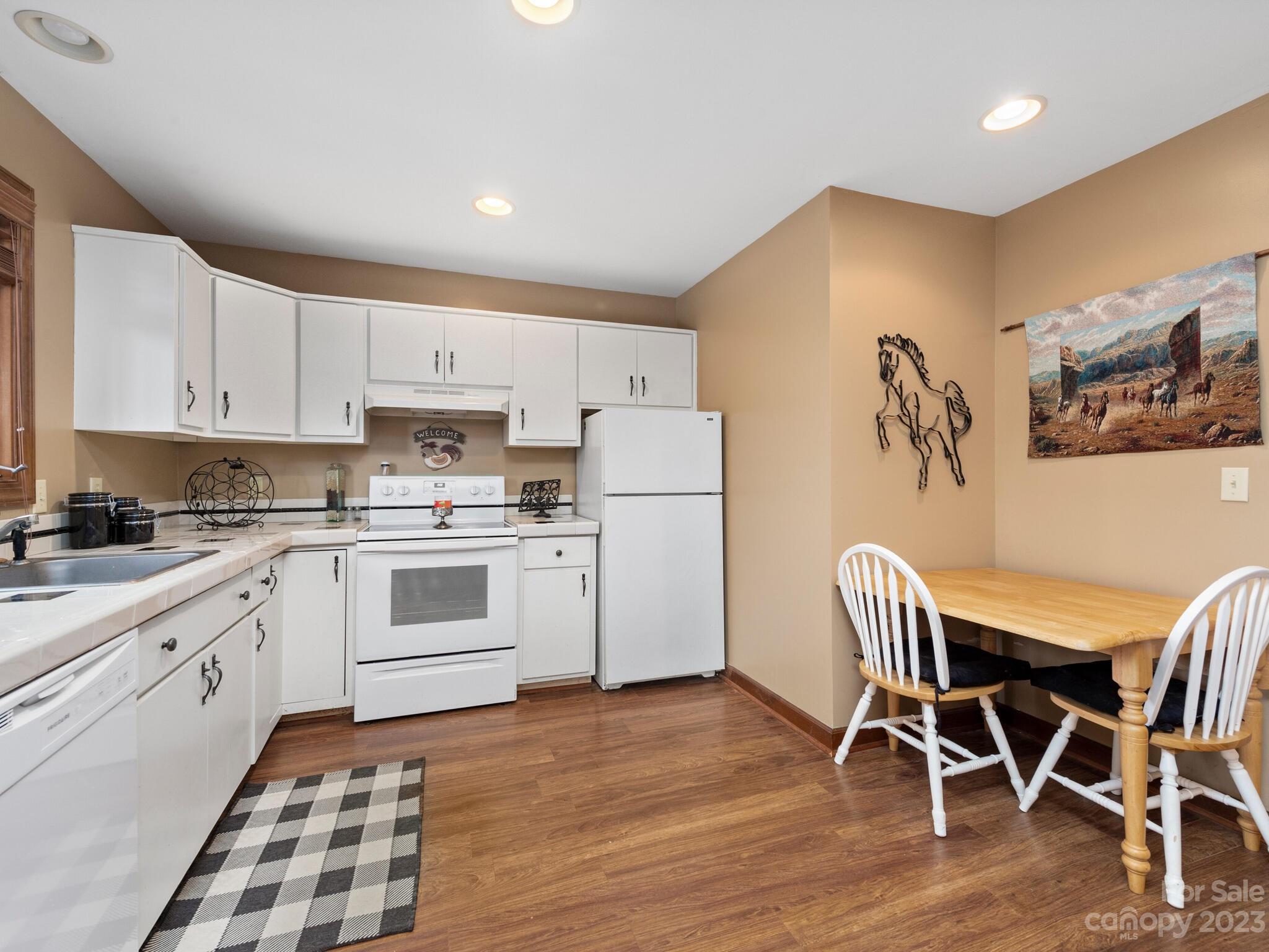 574 Golden Road Columbus, NC 28722 - Photo 44 of 48 a kitchen with granite countertop white cabinets and stainless steel appliances