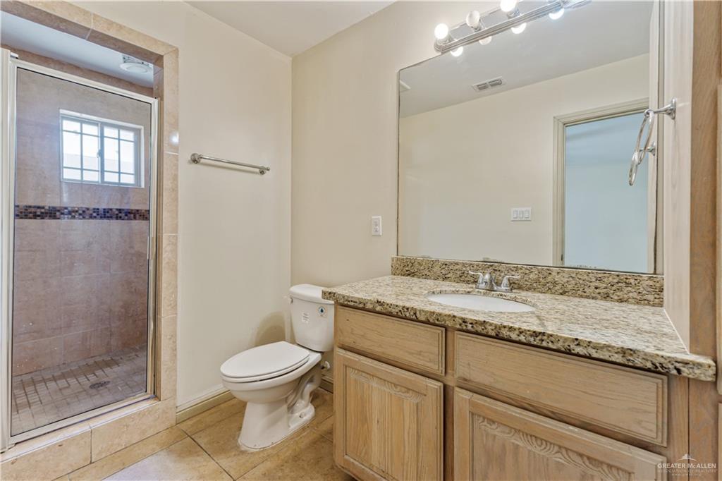1500 Humming Bird Court, Unit 16 Pharr, TX 78577 - Photo 14 of 26 a bathroom with a granite countertop sink toilet a mirror and shower