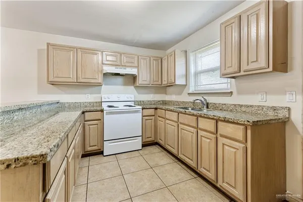 a kitchen with granite countertop white cabinets and white appliances