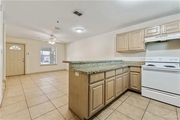 a kitchen with granite countertop a sink and cabinets