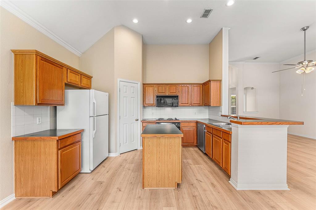111 Midcrest Drive Irving, TX 75063 - Photo 6 of 26 a kitchen with stainless steel appliances granite countertop a stove top oven a sink dishwasher and a refrigerator with wooden floor