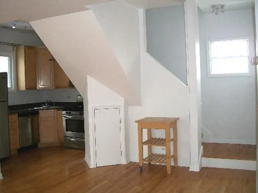 a view of a hallway with wooden floor and staircase
