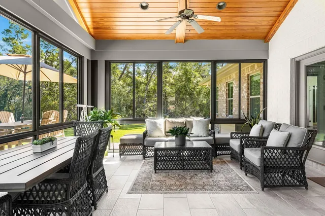 a view of a hallway with wooden floor and a bathroom