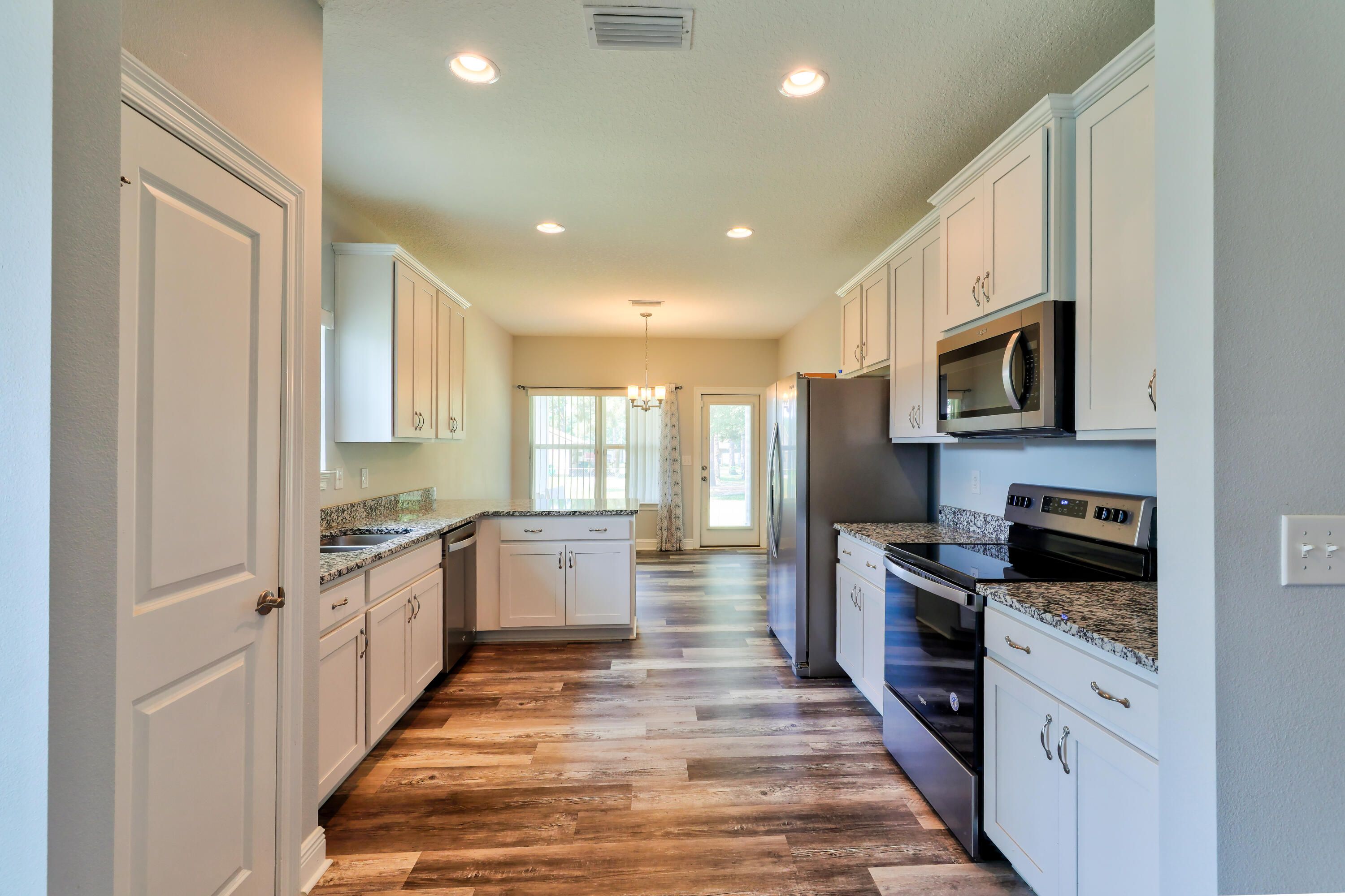 6160 Hayes Drive Crestview, FL 32539 - Photo 20 of 45 a large kitchen with stainless steel appliances granite countertop a stove top oven a sink dishwasher a refrigerator and a microwave