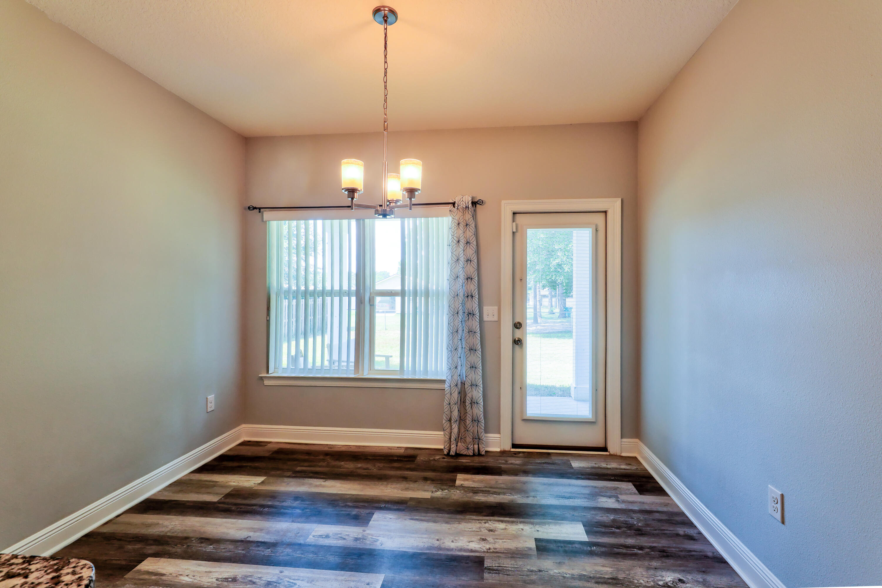 6160 Hayes Drive Crestview, FL 32539 - Photo 22 of 45 a view of an empty room with wooden floor and a window