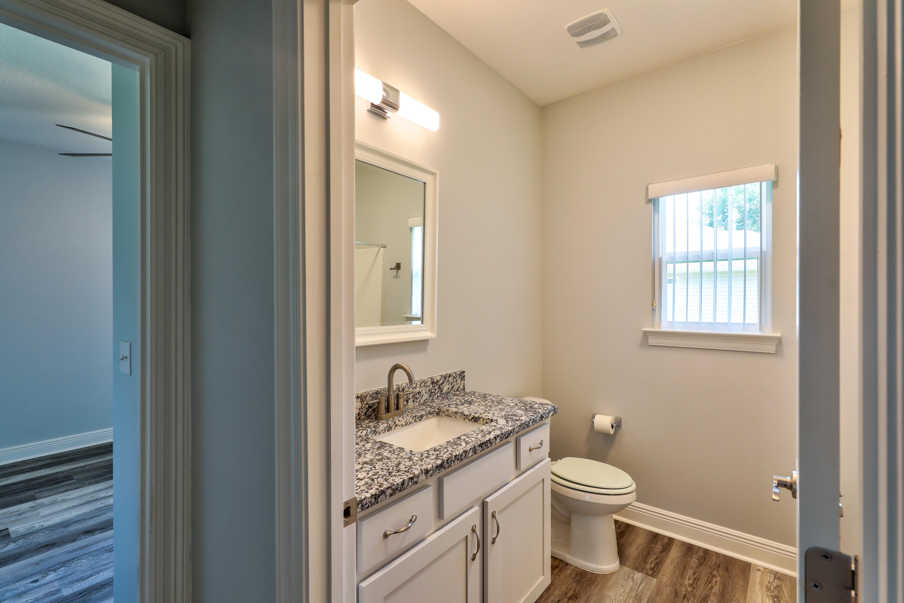 6160 Hayes Drive Crestview, FL 32539 - Photo 24 of 45 a bathroom with a granite countertop sink a toilet and a window
