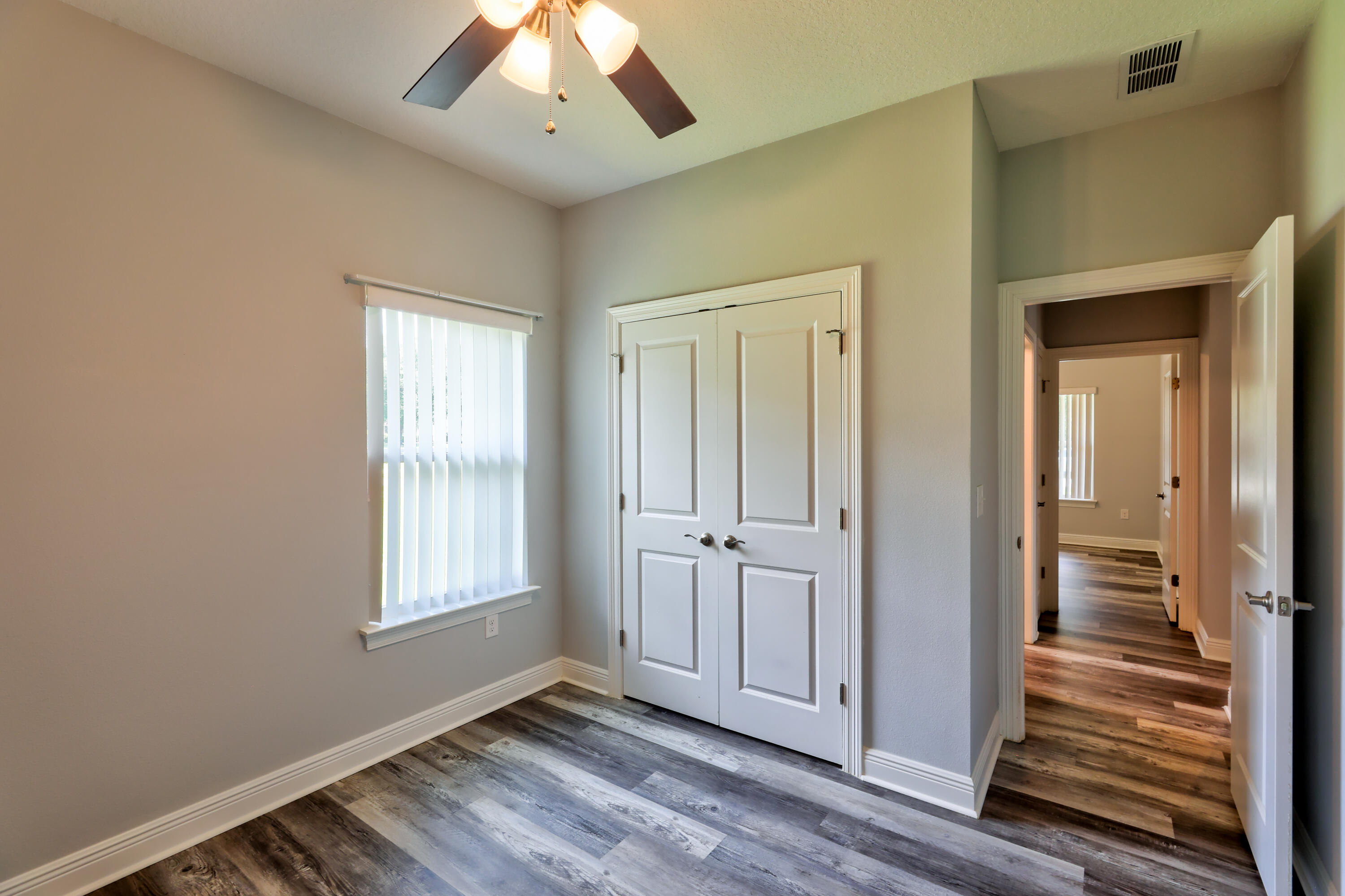6160 Hayes Drive Crestview, FL 32539 - Photo 27 of 45 a view of an empty room with wooden floor and a window