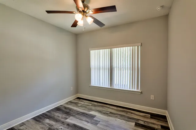 a view of a hallway with wooden floor and closet