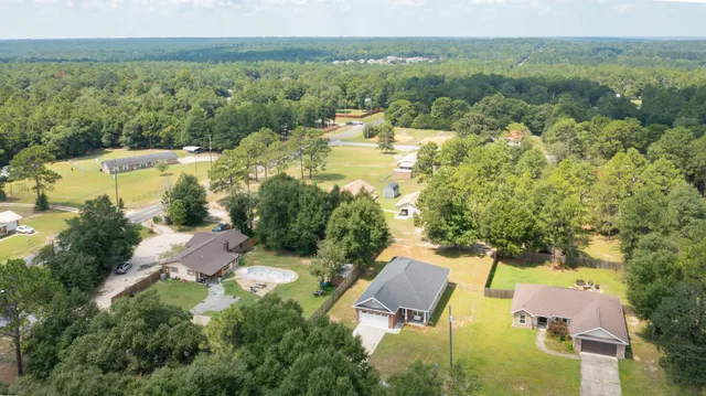 an aerial view of residential houses with outdoor space and river