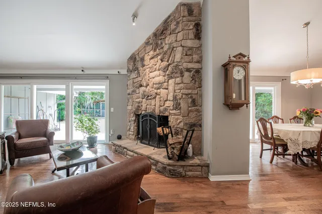 a kitchen with granite countertop a stove top oven a sink dishwasher a dining table and chairs with wooden floor