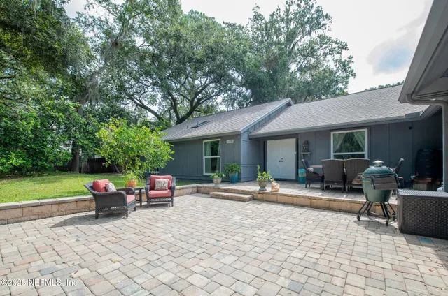 a backyard of a house with yard table and chairs