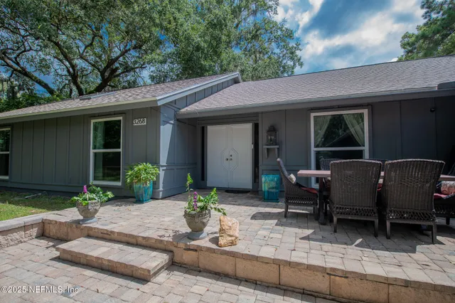 a view of a house with backyard and sitting area